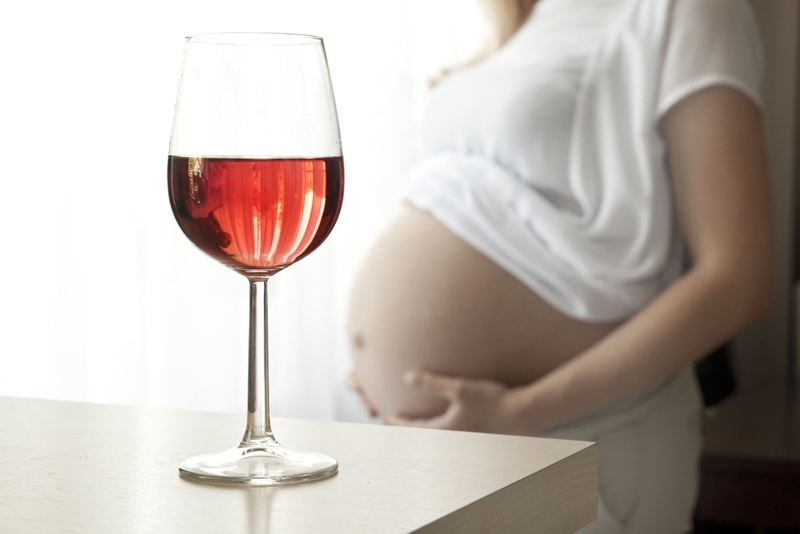 Schwangere und ein Glas Wein
