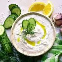 Tzatziki-Sauce, serviert in einer weißen Schale mit Gemüse