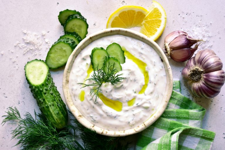 Tzatziki-Sauce, serviert in einer weißen Schale mit Gemüse