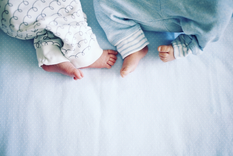 Kleine Beine von zwei neugeborenen Zwillingen