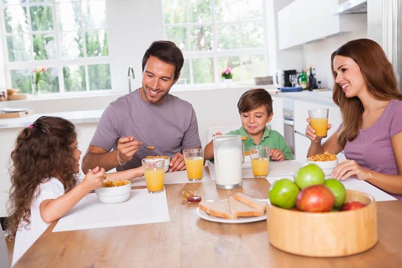 glückliche Familie im Gespräch am Tisch beim Frühstück zu Hause