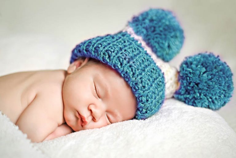 niedlichen Baby Junge schläft mit einem blauen Wintermütze