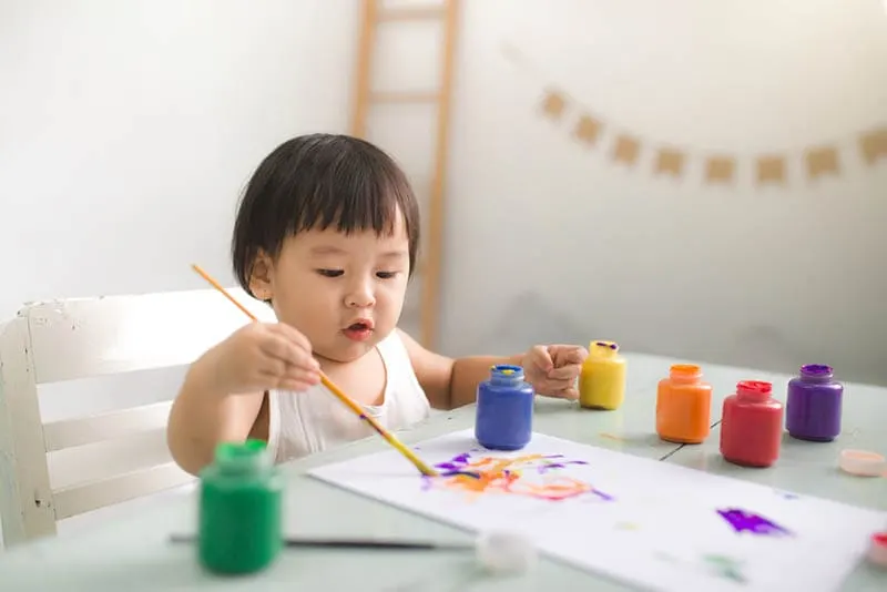 niedlichen Baby sitzt am Tisch und Färbung Zeichnung