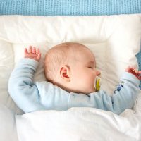 Süßes Baby schlafend mit Schnuller im Bett