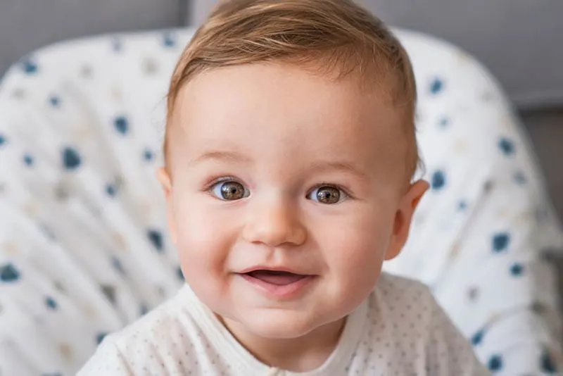 süßes Baby Junge mit hübschen braunen Augen lächelnd