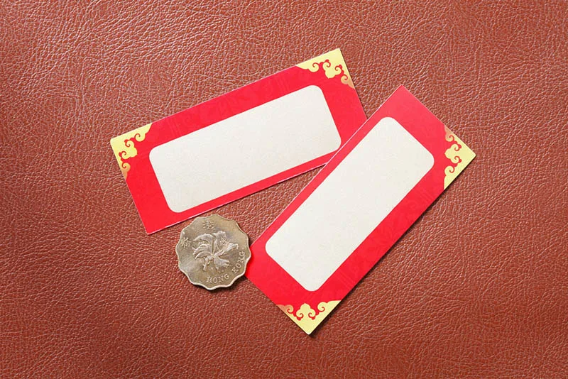zwei Rubbelkarten mit Münze auf dem roten Ledertisch