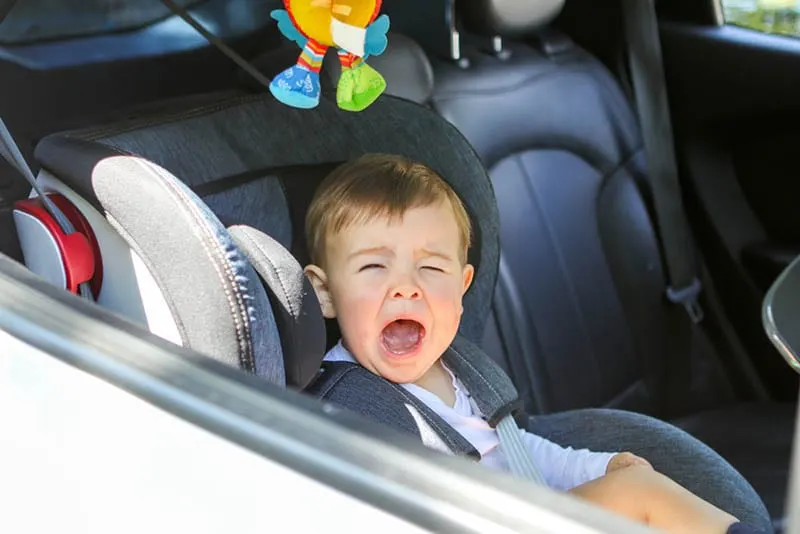 Baby Junge weint in einem Autositz