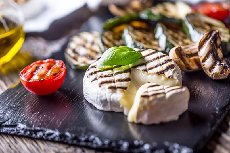 Gegrillter Camembert-Käse mit Zucchini-Tomaten, Olivenöl und Basilikumblättern