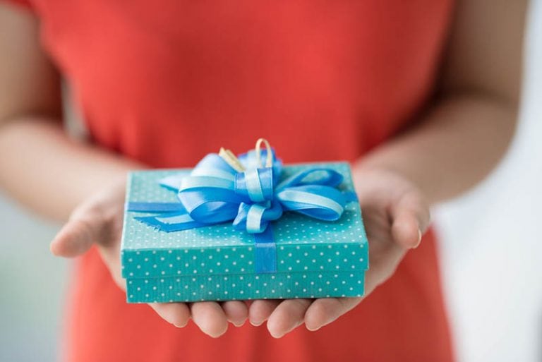 Frau im roten Kleid hält ein Geschenk