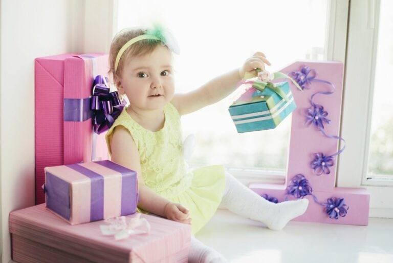 kleines Mädchen mit Geschenken für ihren ersten Geburtstag