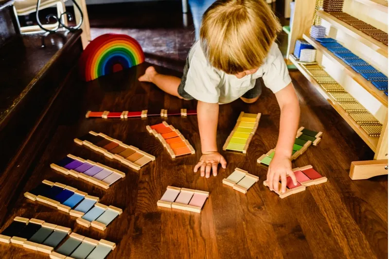 Kinder spielen und lernen mit Montessori-Farbtafeln