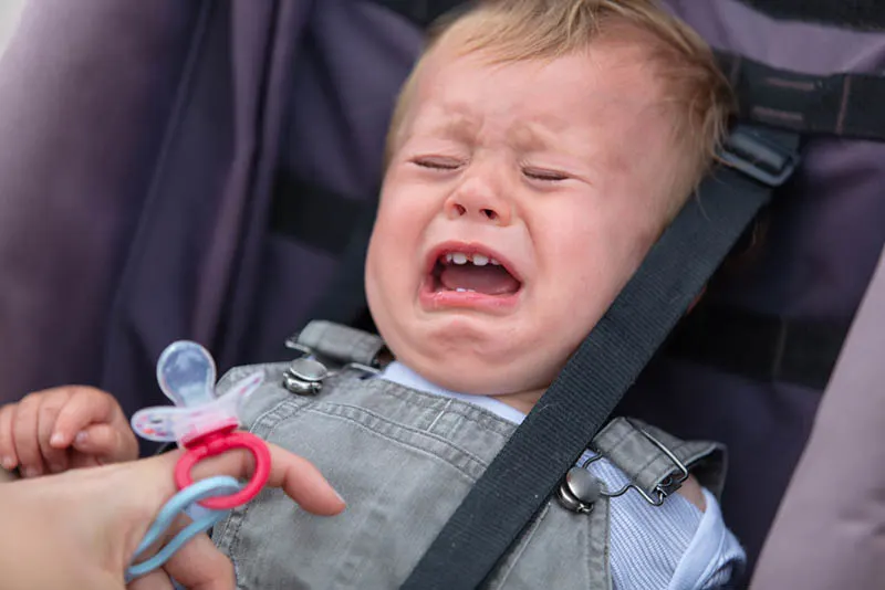 Nettes Baby weint und weigert sich Schnuller