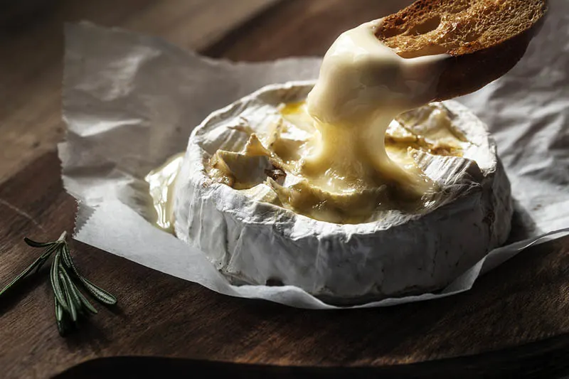Ofengebackener Camembert auf dem Tisch mit Brot