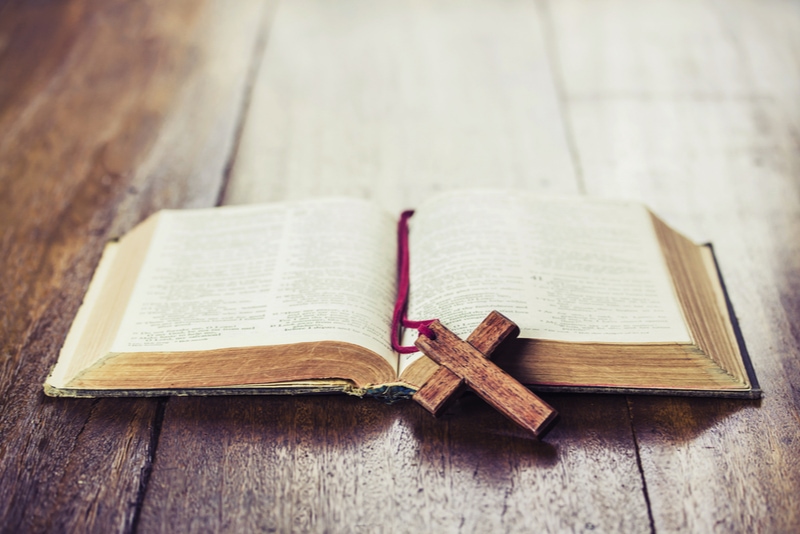 Holzkreuz über geöffnete Bibel