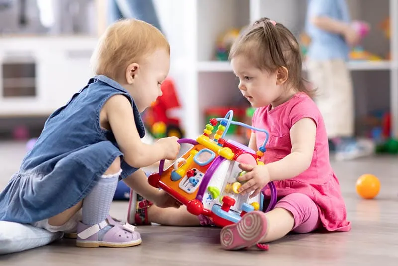niedlichen Baby Mädchen spielen mit Spielzeug auf dem Boden