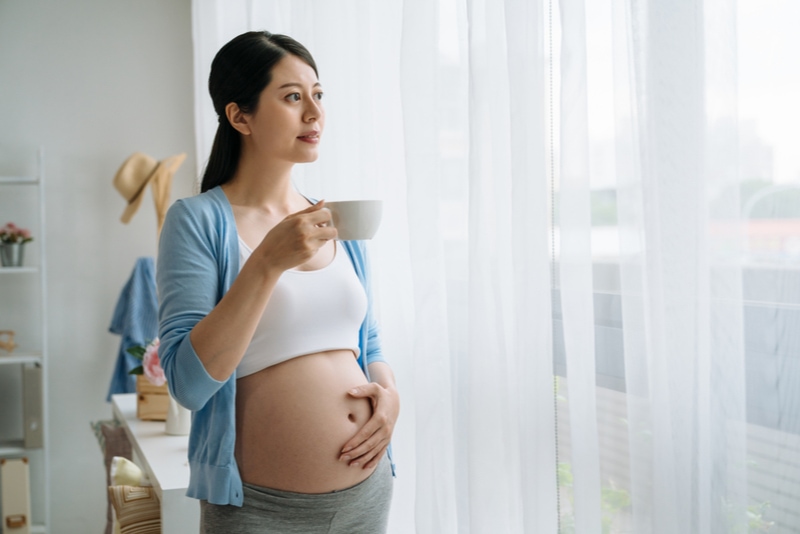 schwangere Frau mit Tasse, die Tee trinkt