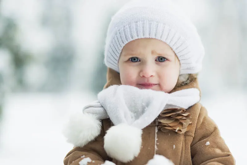 süßes kleines Mädchen im Winterpark stehend
