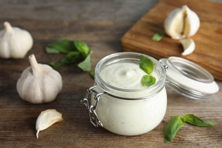 Glas Aioli-Sauce mit Knoblauch auf dem Tisch
