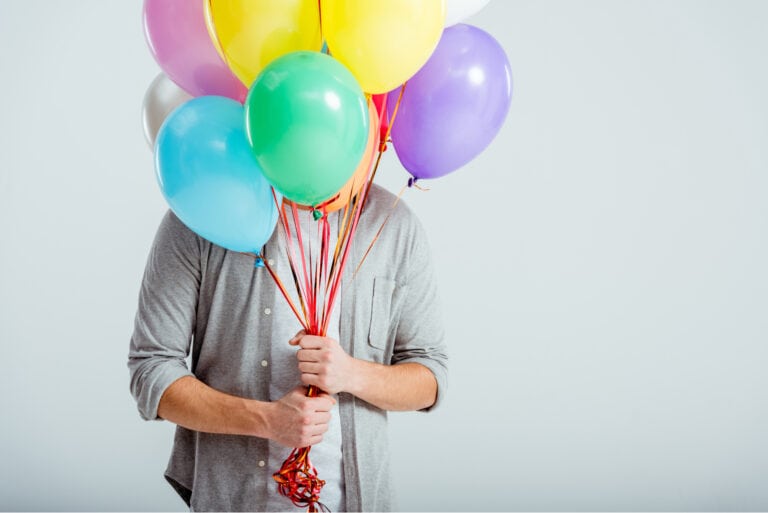 junger Mann mit Geburtstagsballons