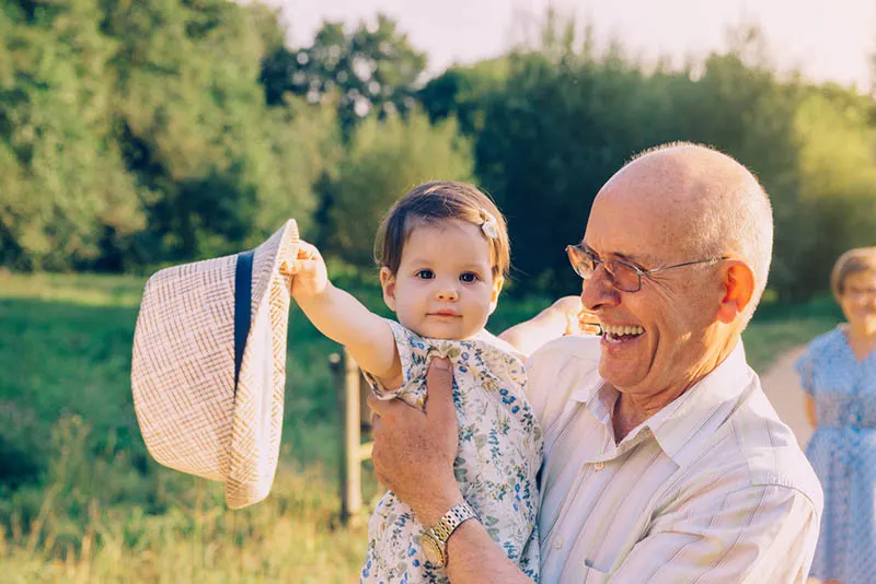 glücklich Großvater hält süße Enkelin in den Armen im Freien