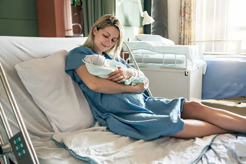 glückliche Mutter mit Baby nach der Geburt im Krankenhaus