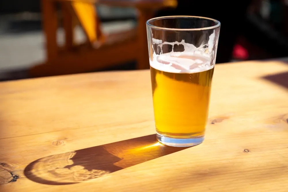 halbvolles Glas Bier auf dem Holztisch