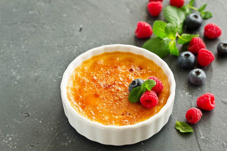 Crème brulee, serviert in einer kleinen weißen Schale mit Beeren