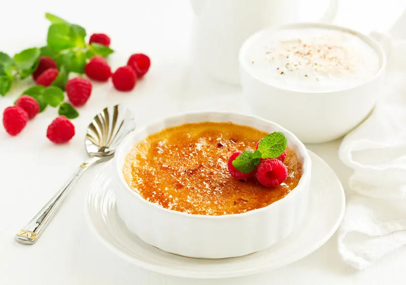 Crème brulee Dessert mit Karamellkruste und Beeren auf dem Tisch