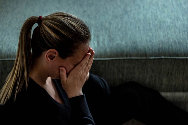 traurige Frau vermisst ihre Mutter und weint, während sie ihr Gesicht mit den Händen bedeckt