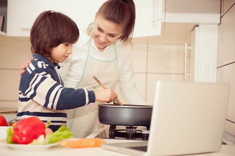 Mutter und Sohn bereiten gemeinsam Essen in der Küche zu