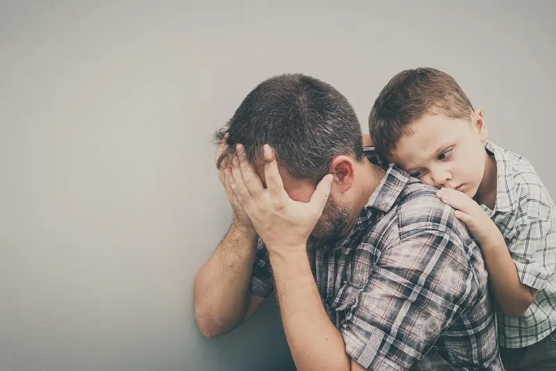 Sohn umarmt seinen frustrierten Vater 