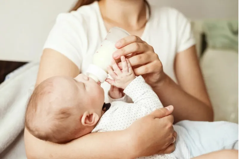 Baby isst Milch aus einer Flasche