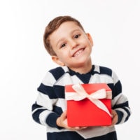5 Jahre alter Junge hält eine rote Geschenkbox