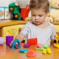 Zweijähriges Kind spielt mit Spielzeug im Kinderzimmer