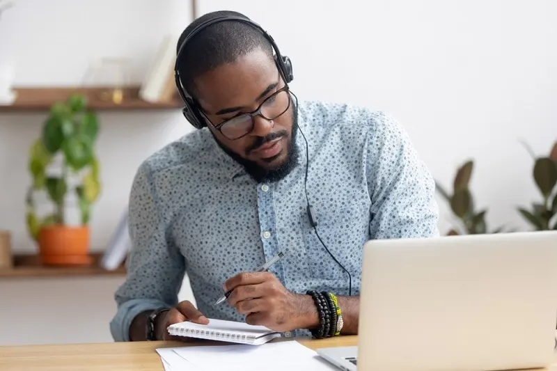 ein junger Mann mit Brille lernt eine neue Sprache auf seinem Laptop