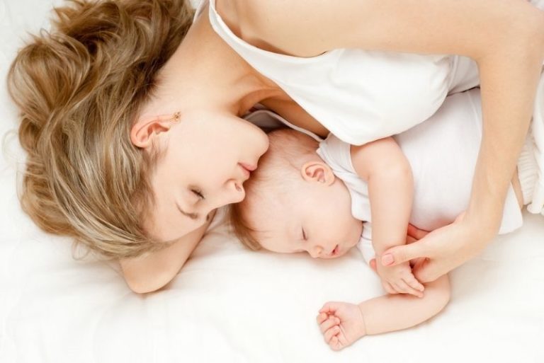Mutter hält ihr Baby fest und schläft