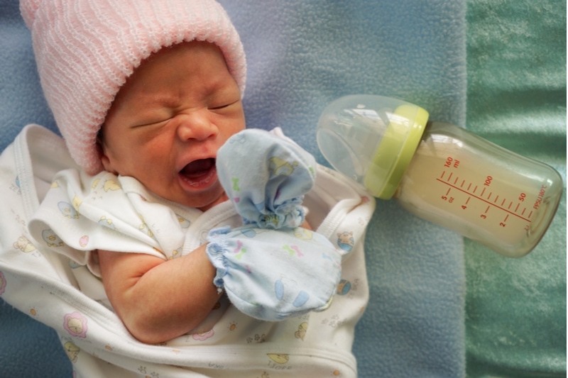 Weinendes Baby lehnt Milchflasche ab