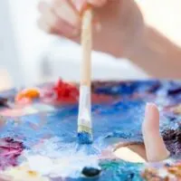 Junge Frau mischt Farbe mit einem Pinsel