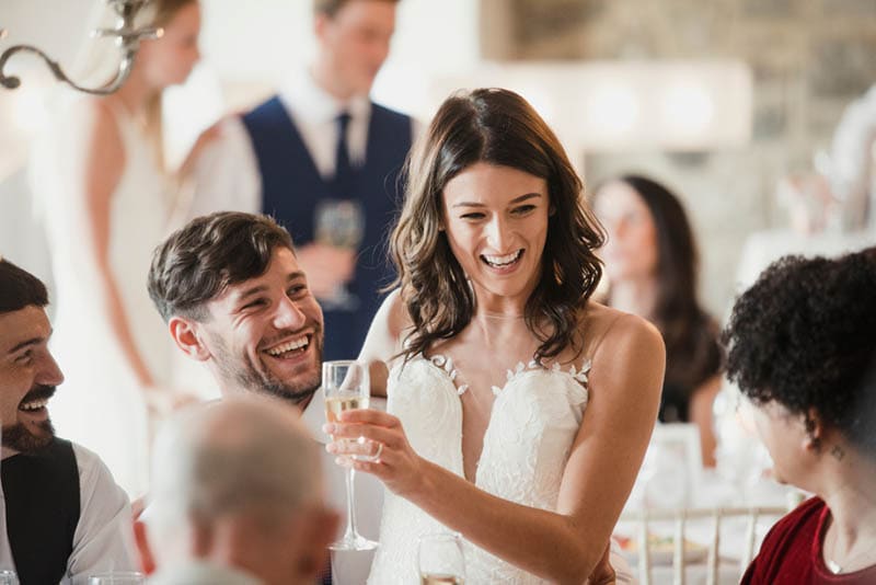 Das glückliche Brautpaar unterhält sich auf der Hochzeitsfeier mit den Gästen