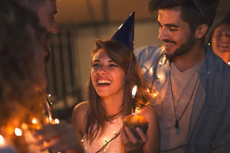 Eine Gruppe junger Freunde feiert eine Geburtstagsparty auf dem Dach eines Gebäudes