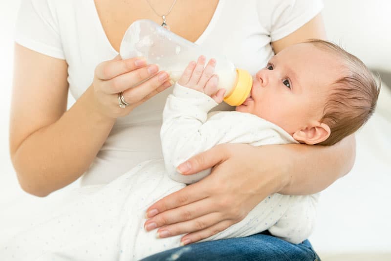 Mutter füttert ihr Baby mit einer Flasche Milch