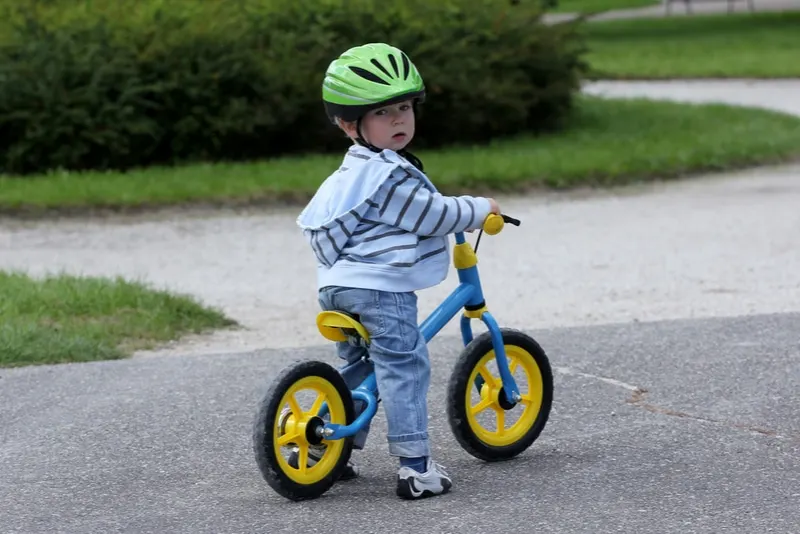 2 Jahre altes Kind lernt auf seinem ersten Fahrrad zu fahren