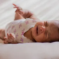 Baby schläft im Bett und weint
