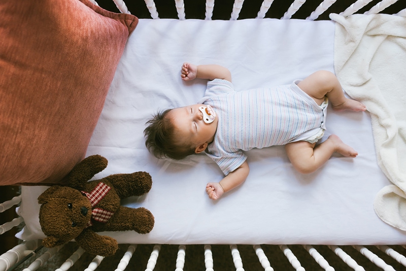 Baby schläft nachts im Kinderbett