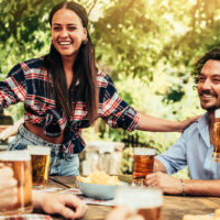 Junge Leute reden und lachen zusammen im Biergarten der Brauerei