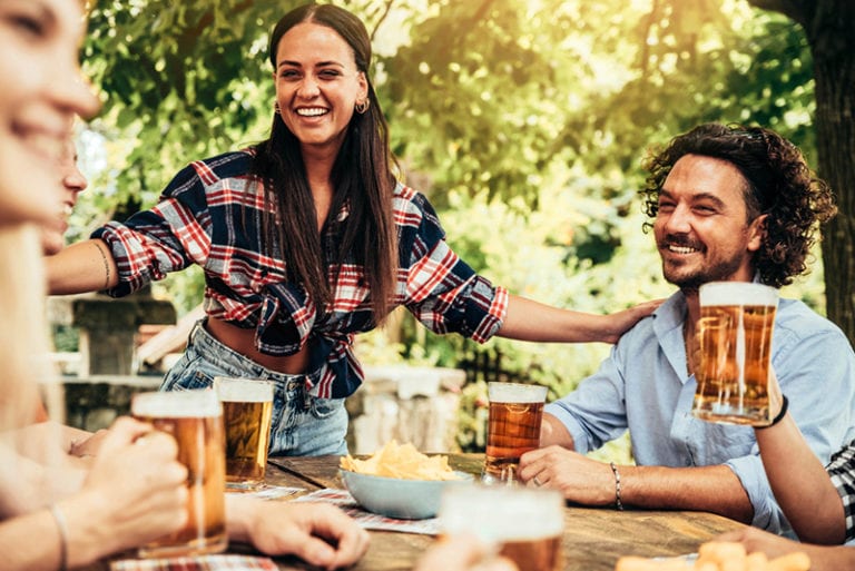 Junge Leute reden und lachen zusammen im Biergarten der Brauerei