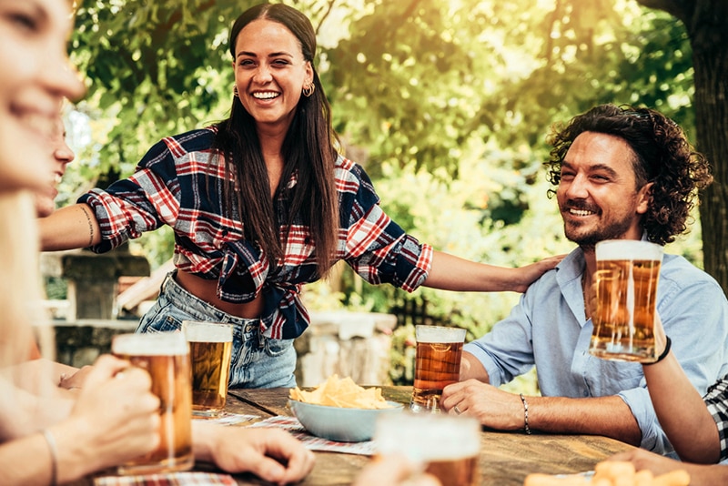 Junge Leute reden und lachen zusammen im Biergarten der Brauerei