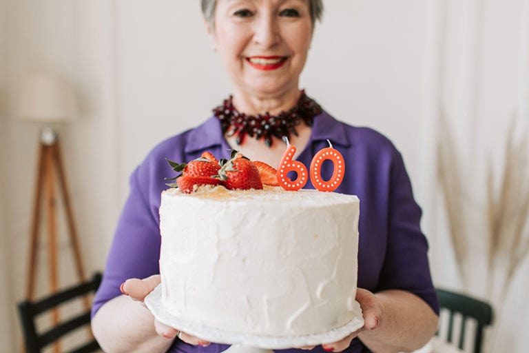 ältere Frau mit Kuchen zum 60. Geburtstag