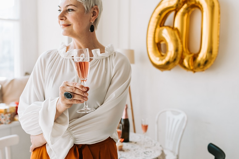 Frau mit einem Glas Champagner zum 60. Geburtstag