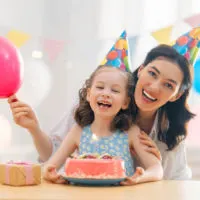 Tante und Tochter feiern Geburtstag mit Kuchen zu Hause